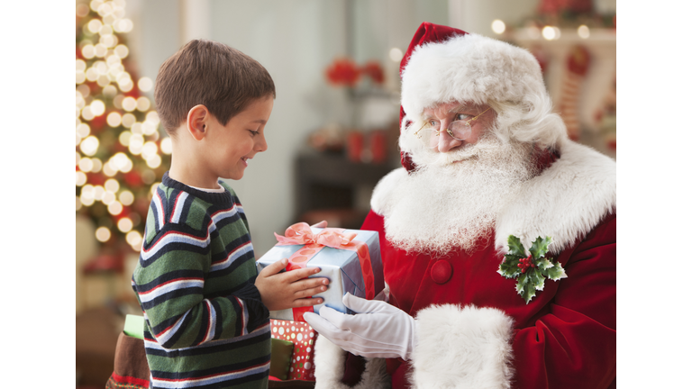 Santa giving Caucasian boy Christmas gift