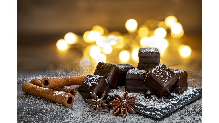 Chocolate dominoes with powdered sugar, cinnamon sticks