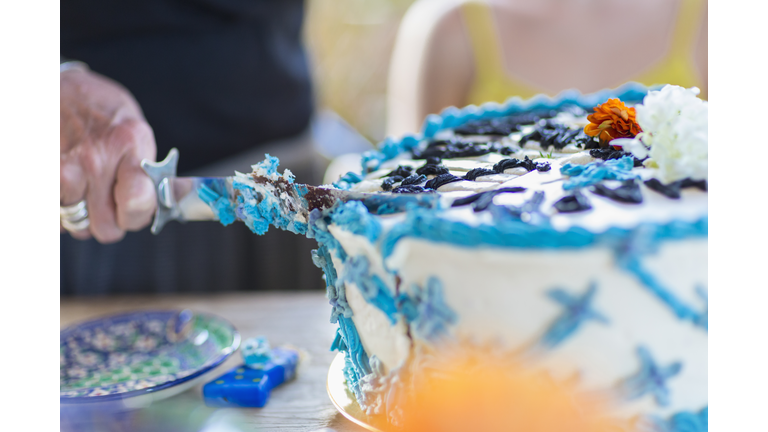 Woman cutting birthday cake at party