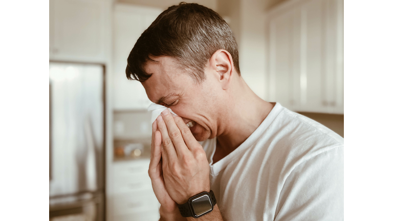 Man Covers Nose During Sneeze