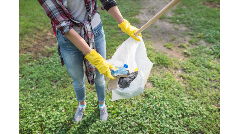 Female volunteer collecting litter thrown in the park
