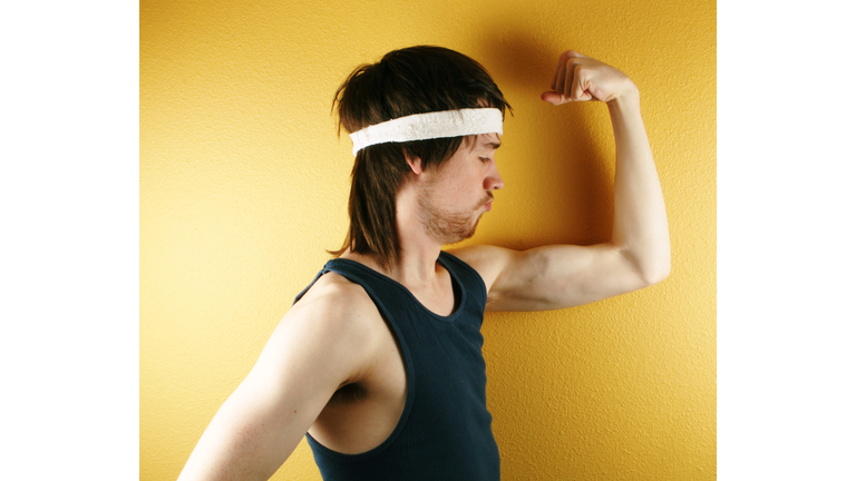 Man posing in retro workout clothes flexing muscle