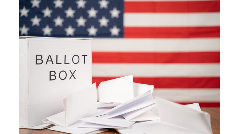 Ballot Box with votes on table before counting with US flag as background concept of Ballot or vote Counting after US election