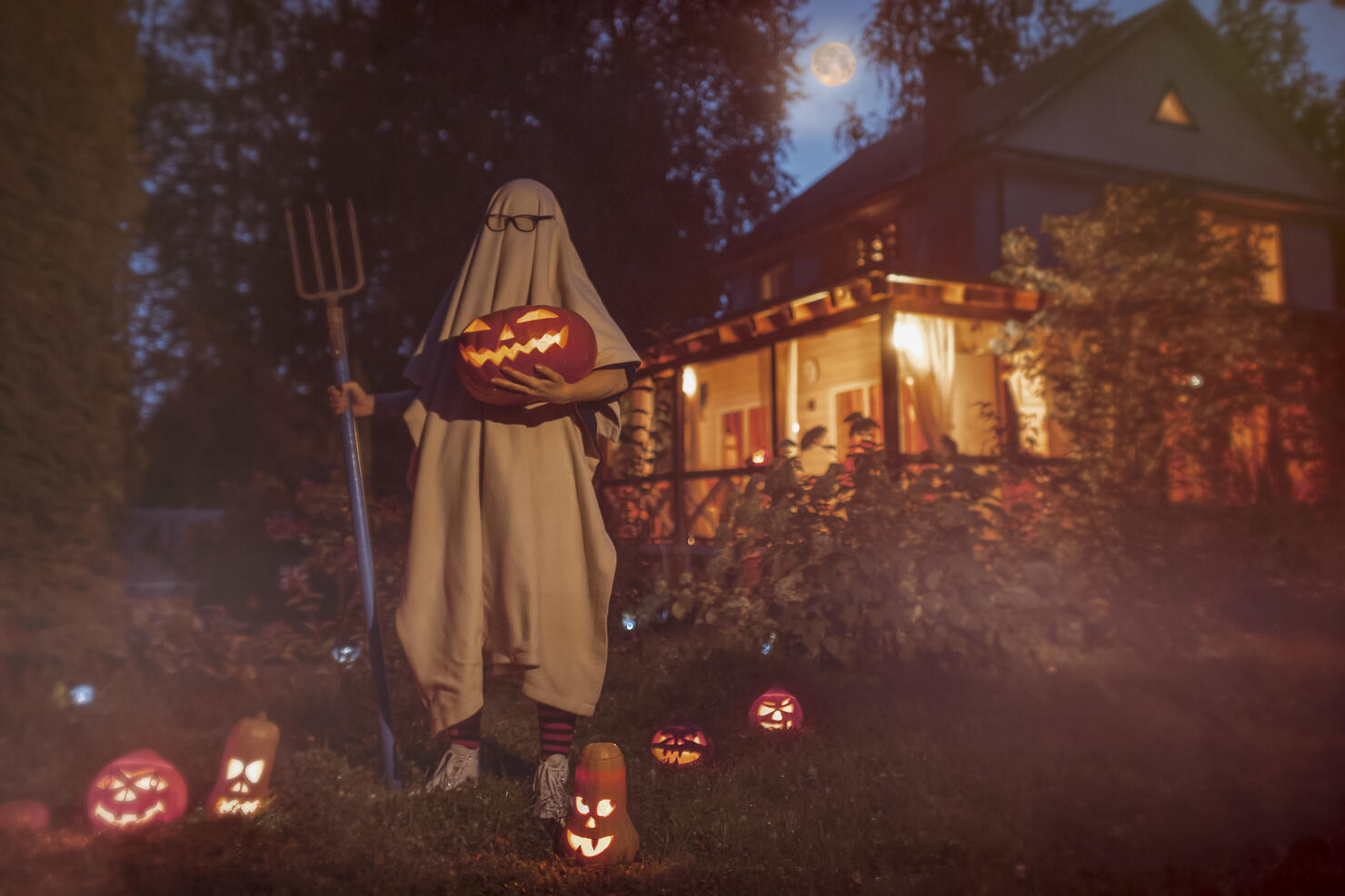 Spooky ghost near haunted house at Halloween