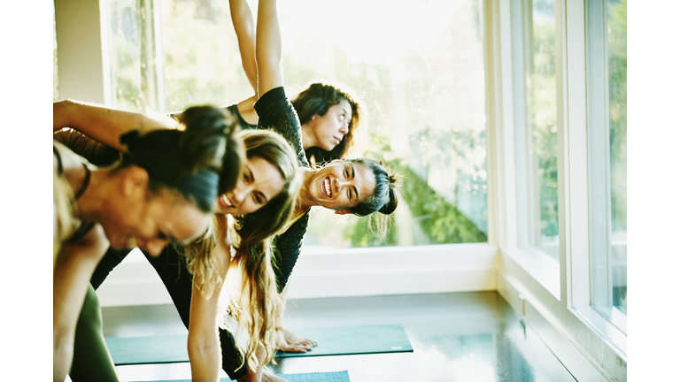 Woman laughing with friends during yoga class