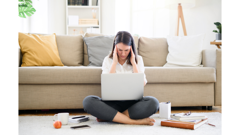 Stressed and frustrated young woman with laptop working in home office, quarantine concept.