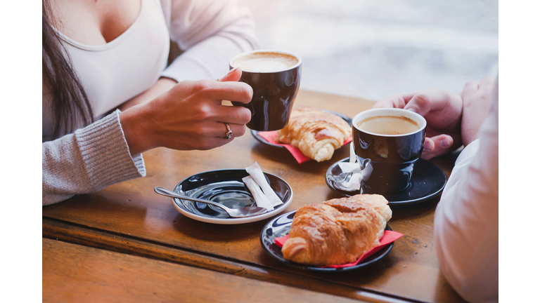 coffee and croissants in cafe, couple having breakfast