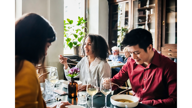 Group Of Friends Eating Lunch Together In Restaurant