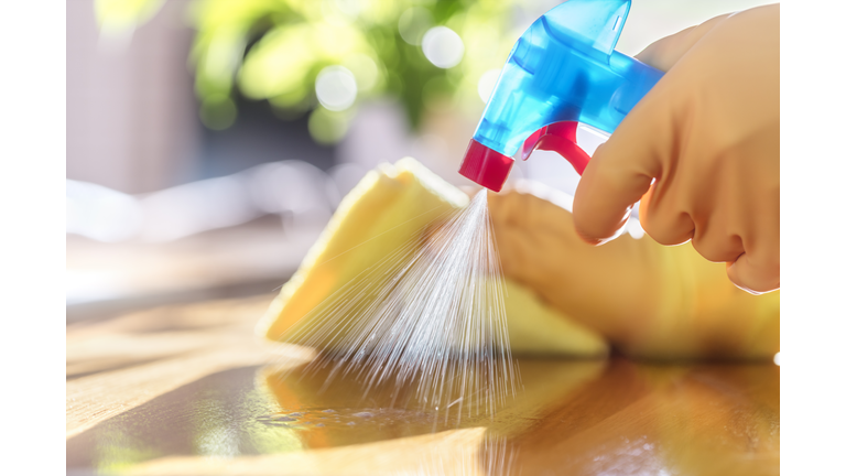 Cleaning with spray detergent, rubber gloves and dish cloth on work surface