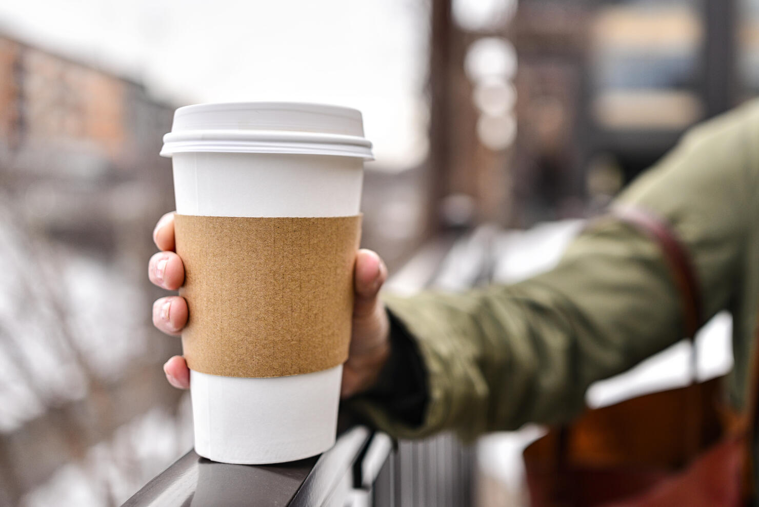 Holding a Blank Coffee Cup with Bokeh City Background
