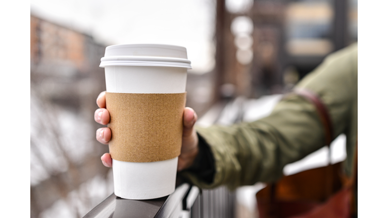 Holding a Blank Coffee Cup with Bokeh City Background