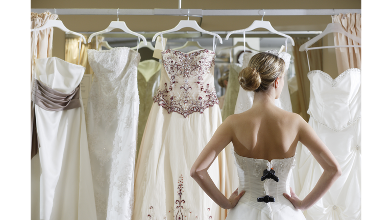 Bride looking at rack of dresses