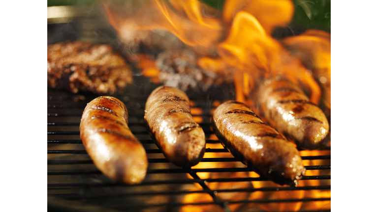 bratwursts cooking over fire on barbecue grill