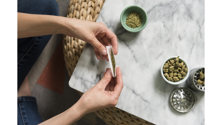 Hands of woman rolling marijuana joint