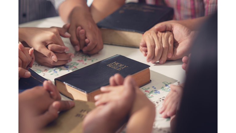 Christians  and Bible study concept. Group of discipleship Studying the Word Of God in church and Christians holding each others hand praying together