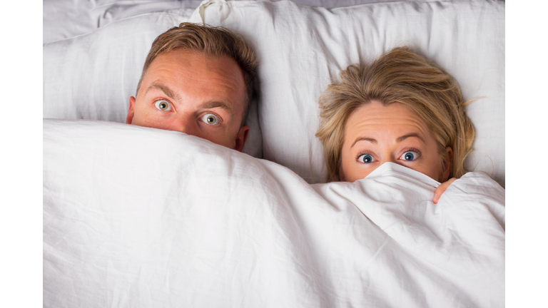 Couple hiding under sheets