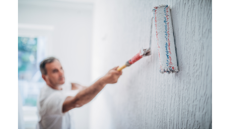 Painter man at work with a paint roller