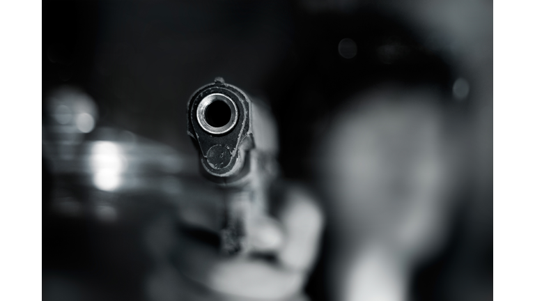 Black and white, woman pointing old gun to front