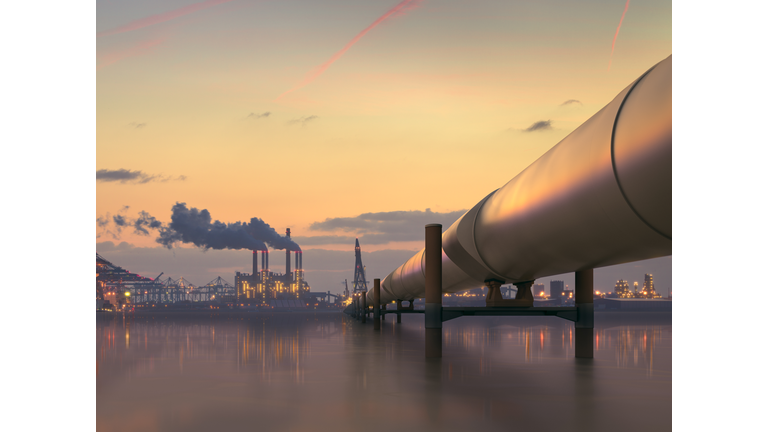 Oil pipeline in industrial district with factories at dusk