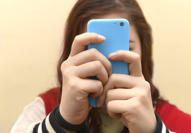 OBSESSIVE TEENAGER TEXTING ON SMART PHONE
