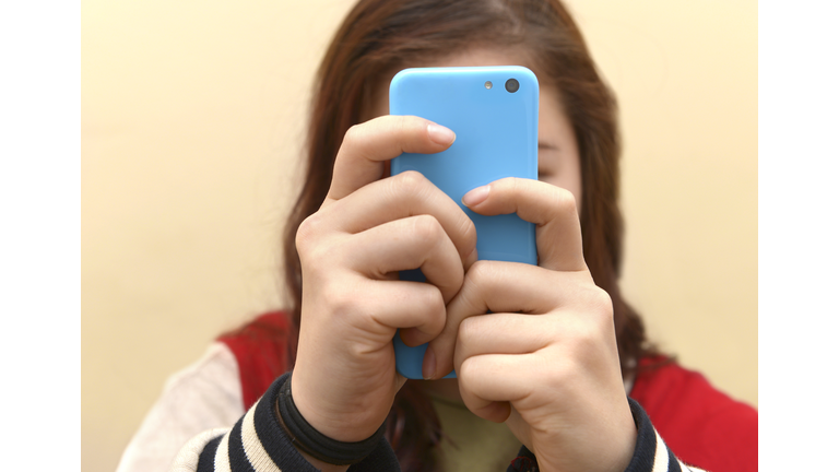 OBSESSIVE TEENAGER TEXTING ON SMART PHONE
