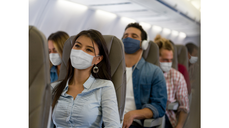 Woman traveling by plane wearing a facemask