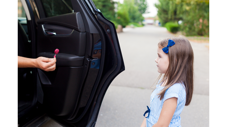 Stranger in the car offers candy to the child. Kids in danger. Children safety protection kidnapping concept