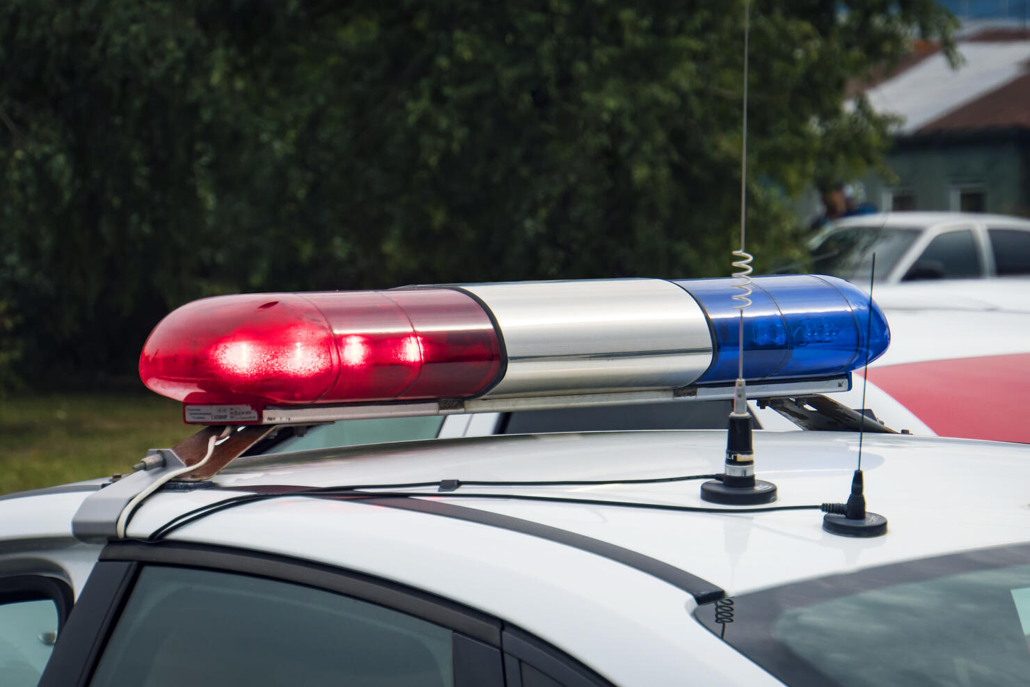 A close up of a swithched rotating beacon of a police car. Cop car rooftop flashing lights outdoors. The top of the police patrol car with flasher and antennas. A patrol car lights. Accident.