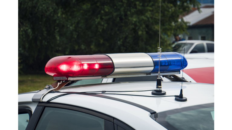 A close up of a swithched rotating beacon of a police car. Cop car rooftop flashing lights outdoors. The top of the police patrol car with flasher and antennas. A patrol car lights. Accident.