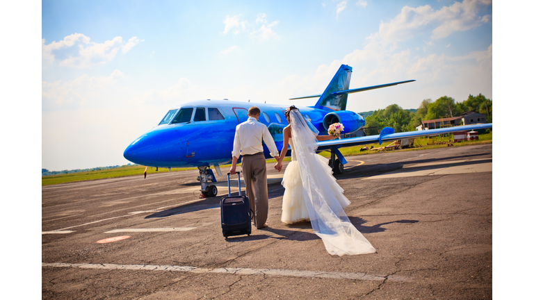 A bride and groom boarding a plane