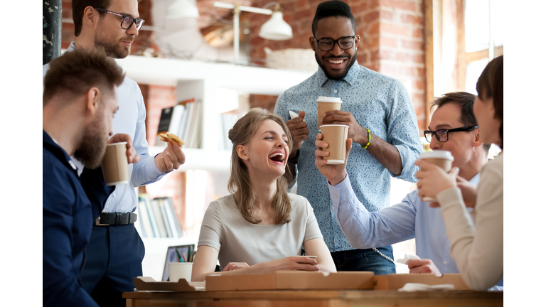 Happy diverse colleagues celebrate during lunch break in office