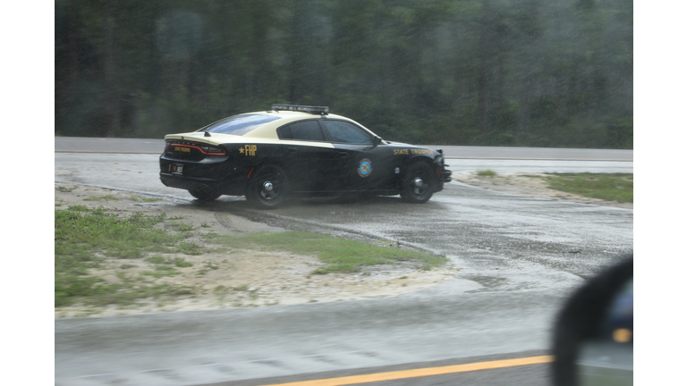 Highway patrol vehicle watching for speeding motorists in a rain storm