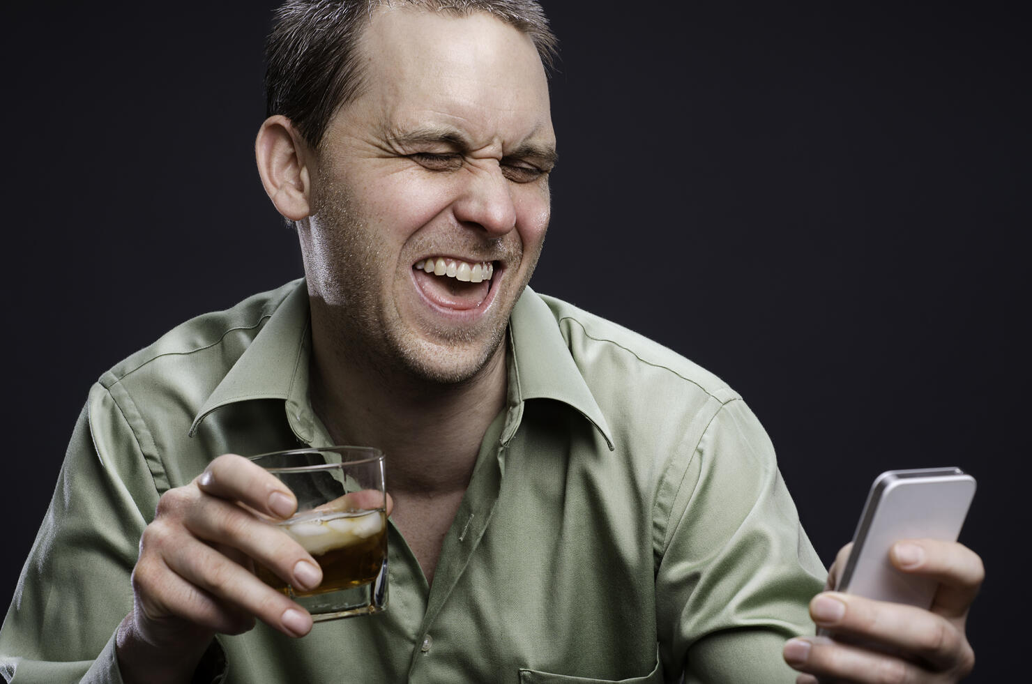 A drunk man drinking and texting
