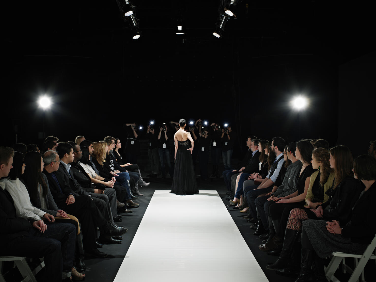 Model in gown at end of catwalk posing