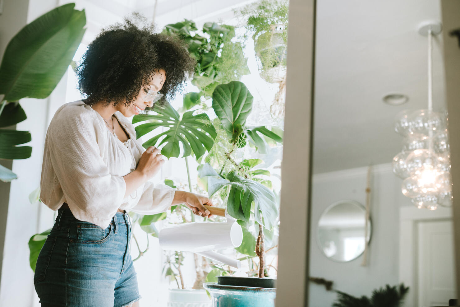 A Young Woman Waters Her Houseplants