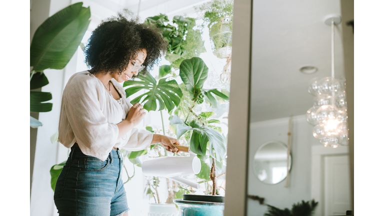 A Young Woman Waters Her Houseplants