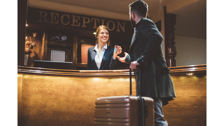 Receptionist giving keys to hotel guest