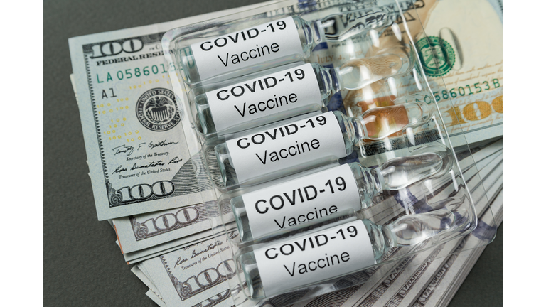 Vials of vaccine from Covid-19 lie on stack of money. Expensive drugs for coronavirus