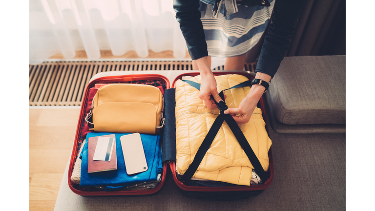 Tourist woman packing the suitcase before leaving