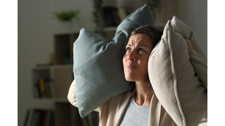 Annoyed adult woman suffering neighbour noise at night at home