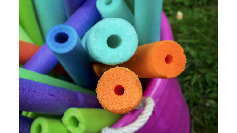 Bucket full of foam pool noodles