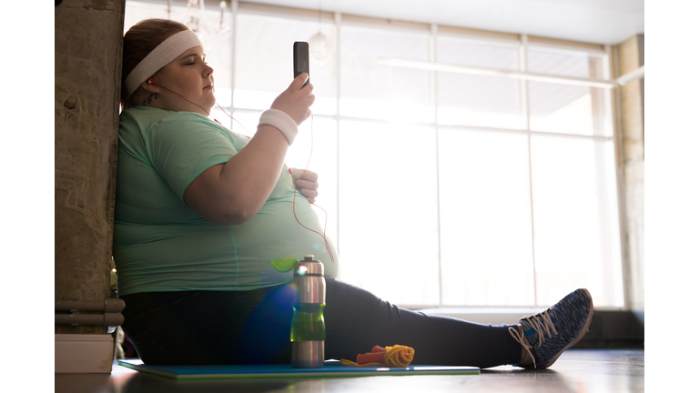 Obese Woman Using Smartphone after Workout