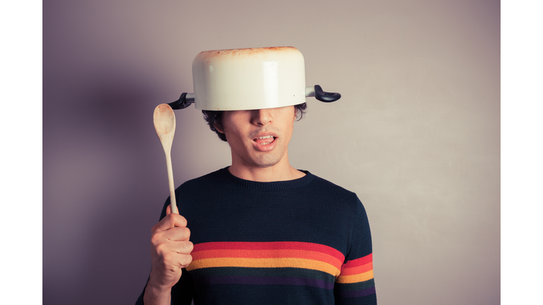 Silly young man with pot on his head