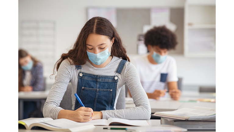 High school girl studying in class with face mask