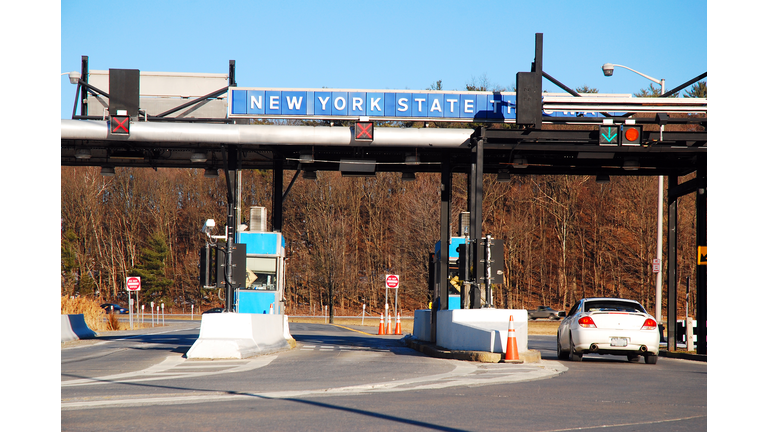 A car pulls up to a toll booth at the New York State Thruway