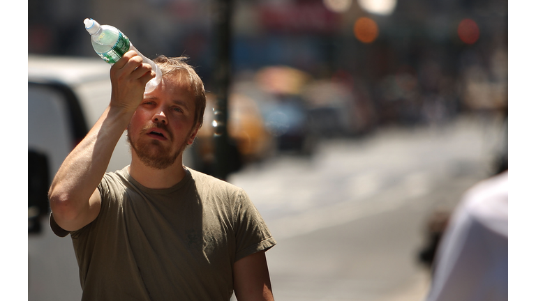 Man cools himself with a bottle of water.