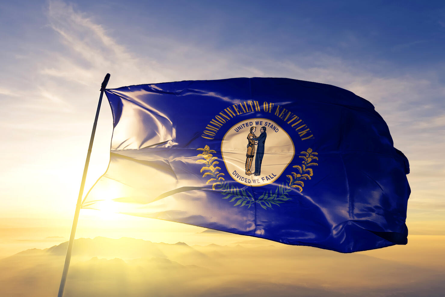 Kentucky state of United States flag textile cloth fabric waving on the top sunrise mist fog