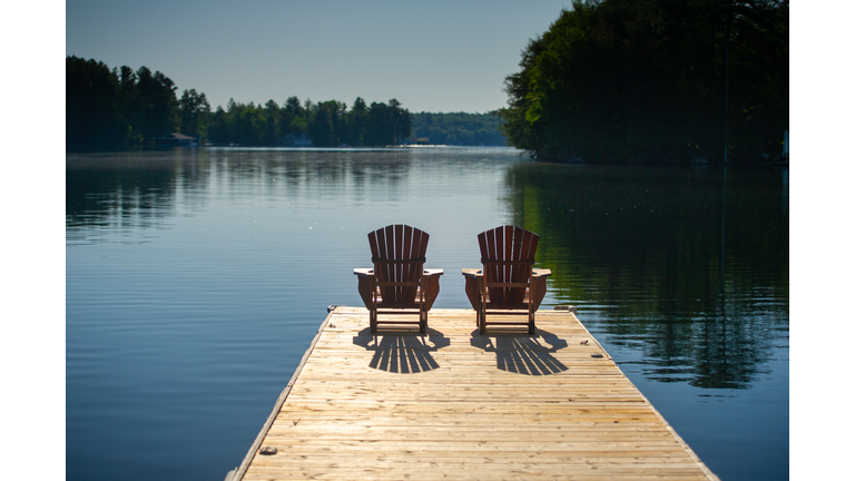 Adirondack chairs sitting on a wooden pier