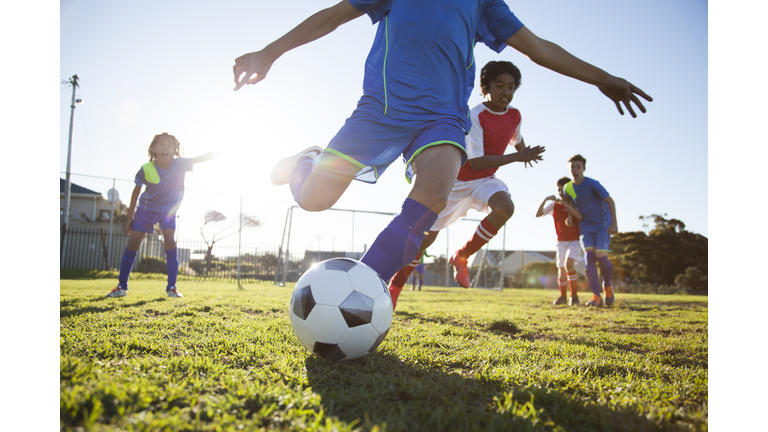 Close up of boy kicking soccer ball