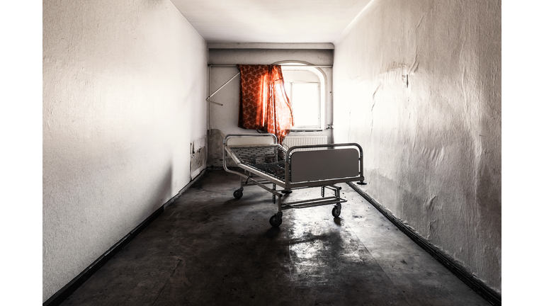 One old bed in a room in an abandoned hospital